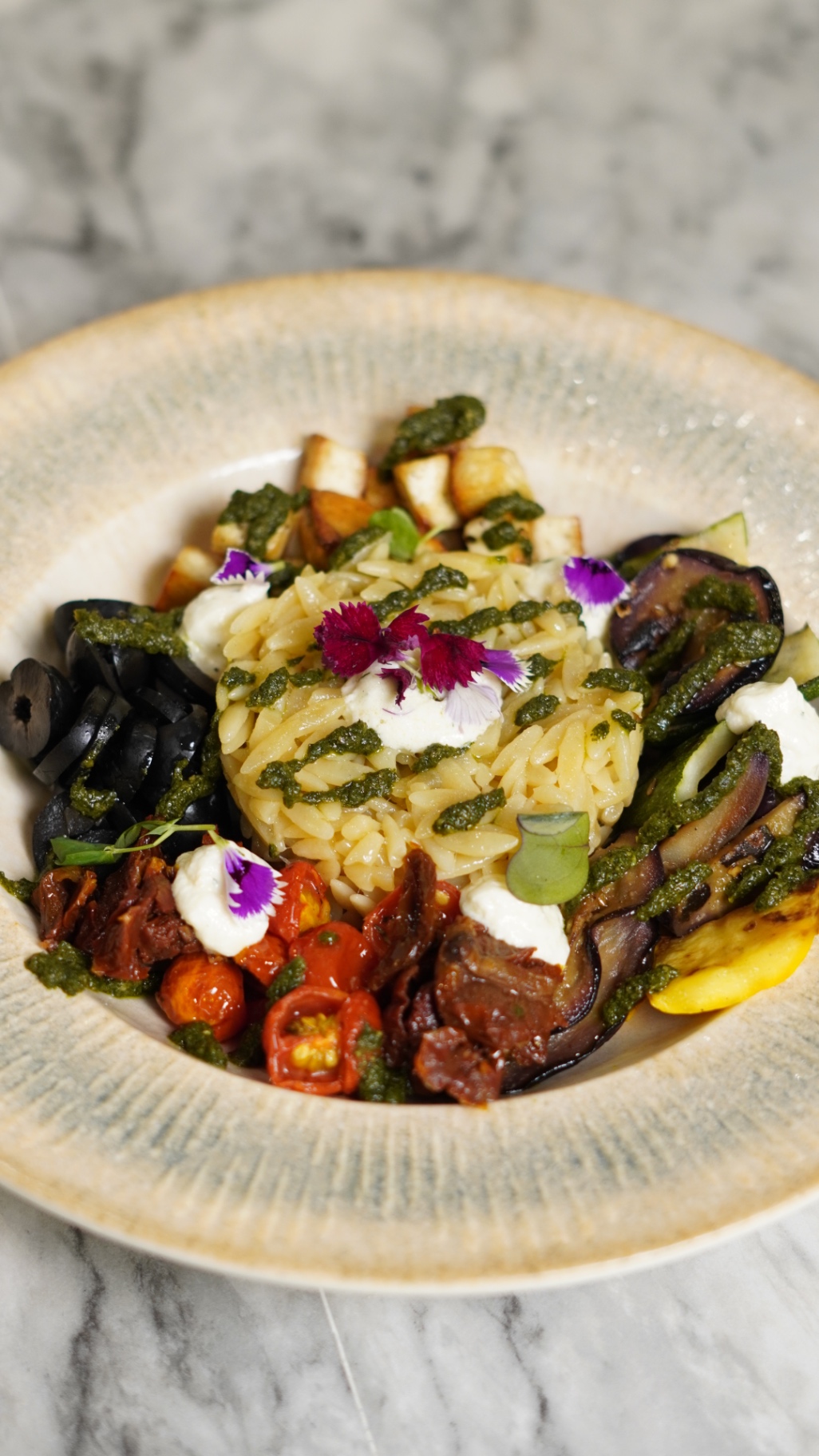 Orzo pesto bowl with olives, sundried tomatoes and grilled vegetables